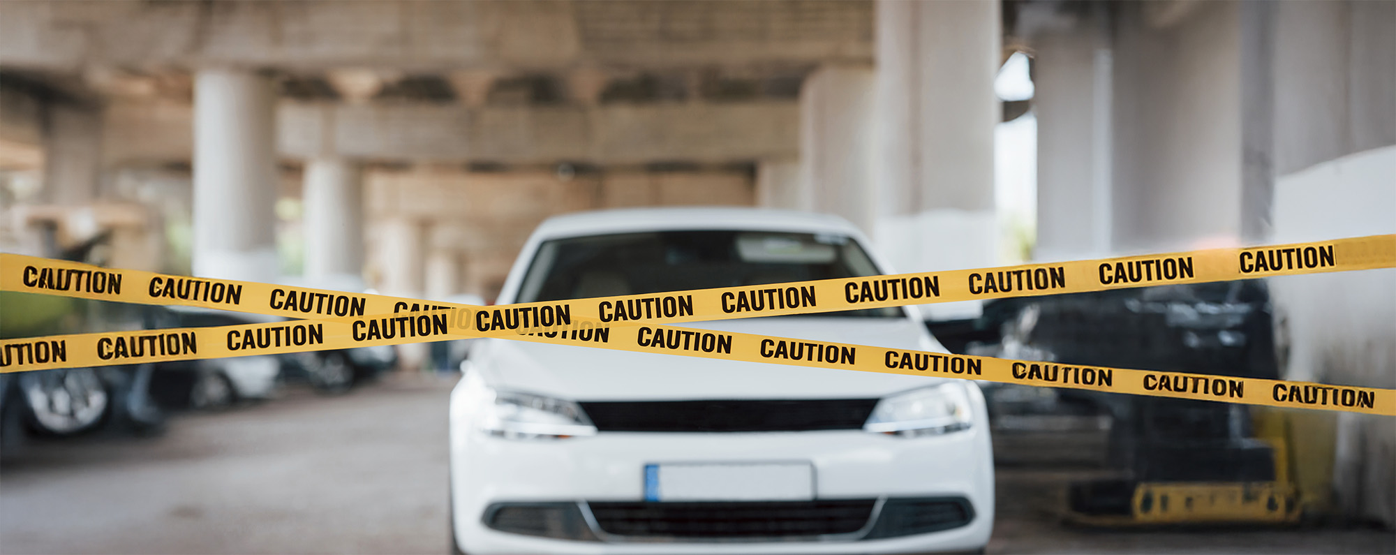 White colored automobile Yellow caution tape near the car parking lot at daytime Crime scene