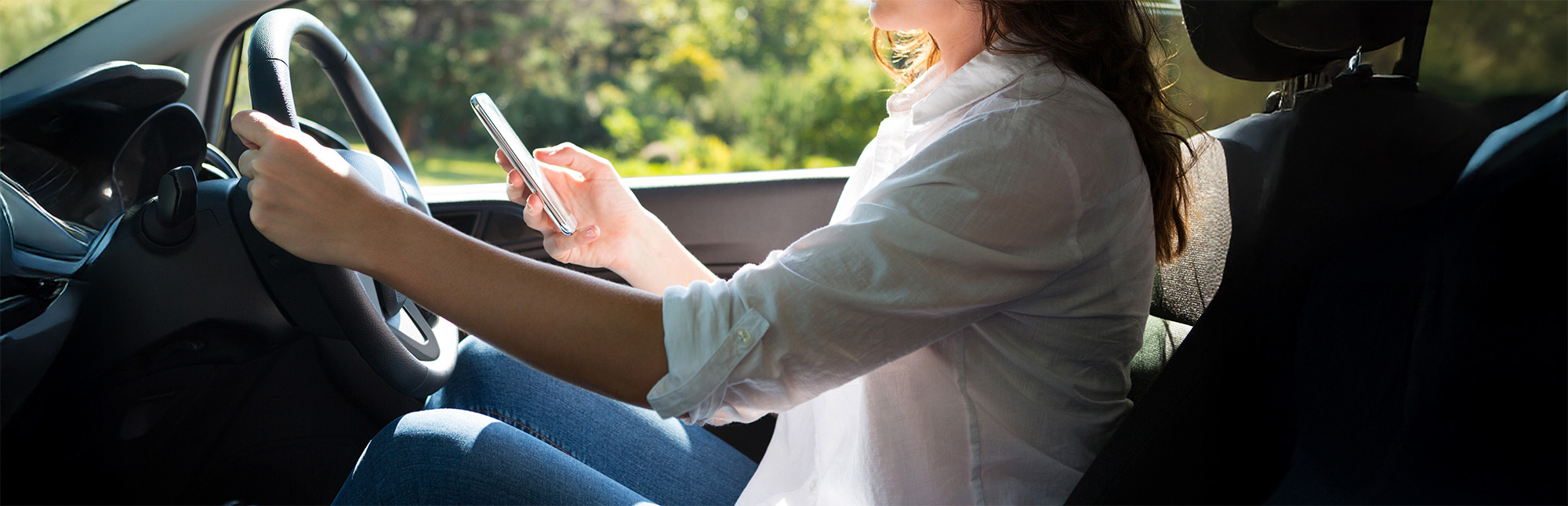Woman using mobile phone while driving a car