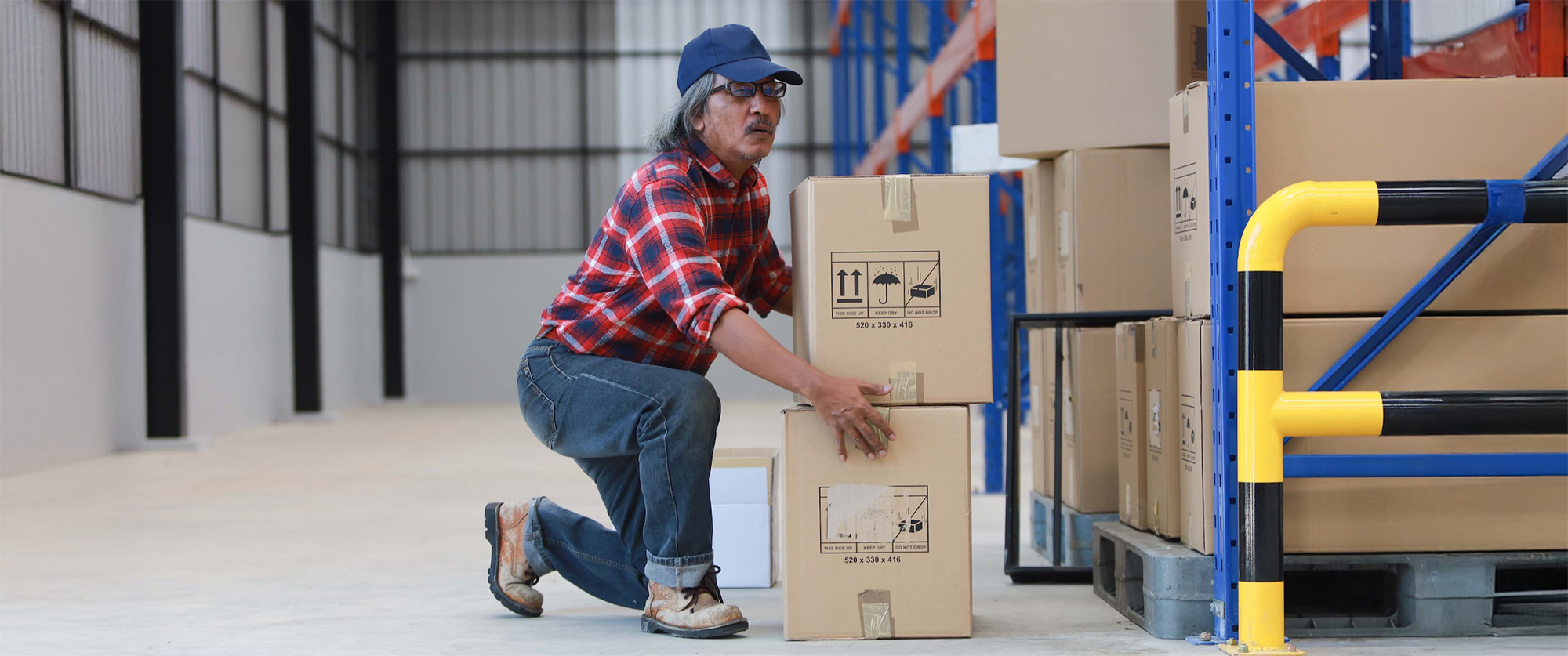 asian worker man hurt his back _lift heavy box in factory