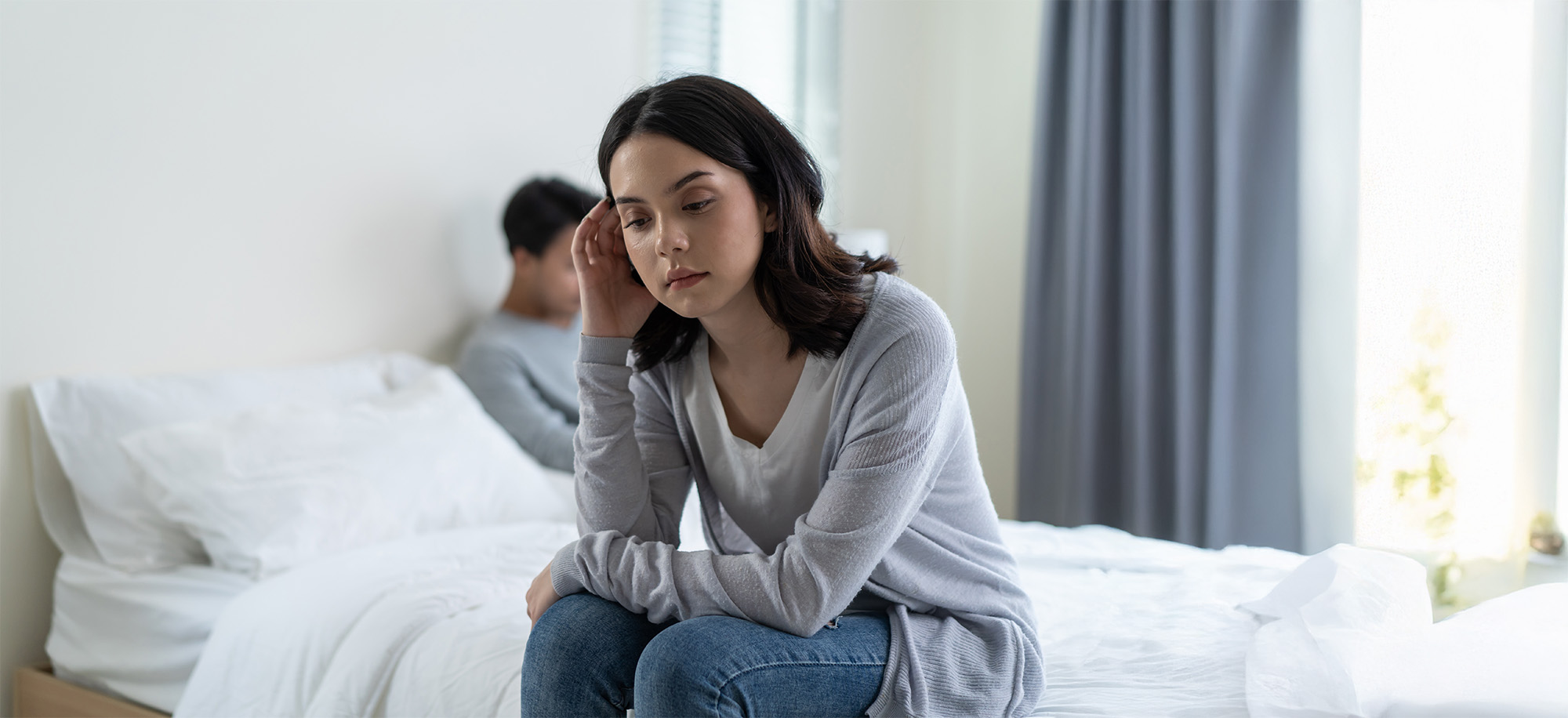 man and woman feel heartbroken for quarrel conflict while sit on bed in bedroom